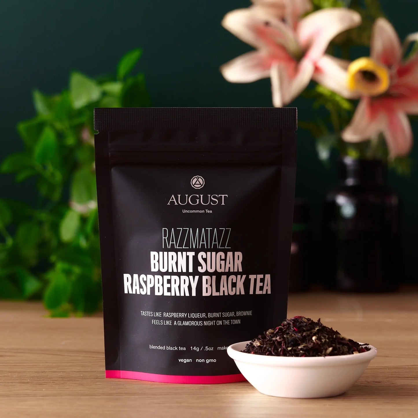 AUGUST RAZZMATAZZ burnt sugar raspberry black tea bag with bowl of leaves