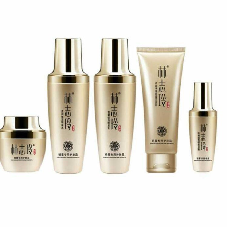 Moisturizing skincare set with five gold-toned bottles and one cream tube