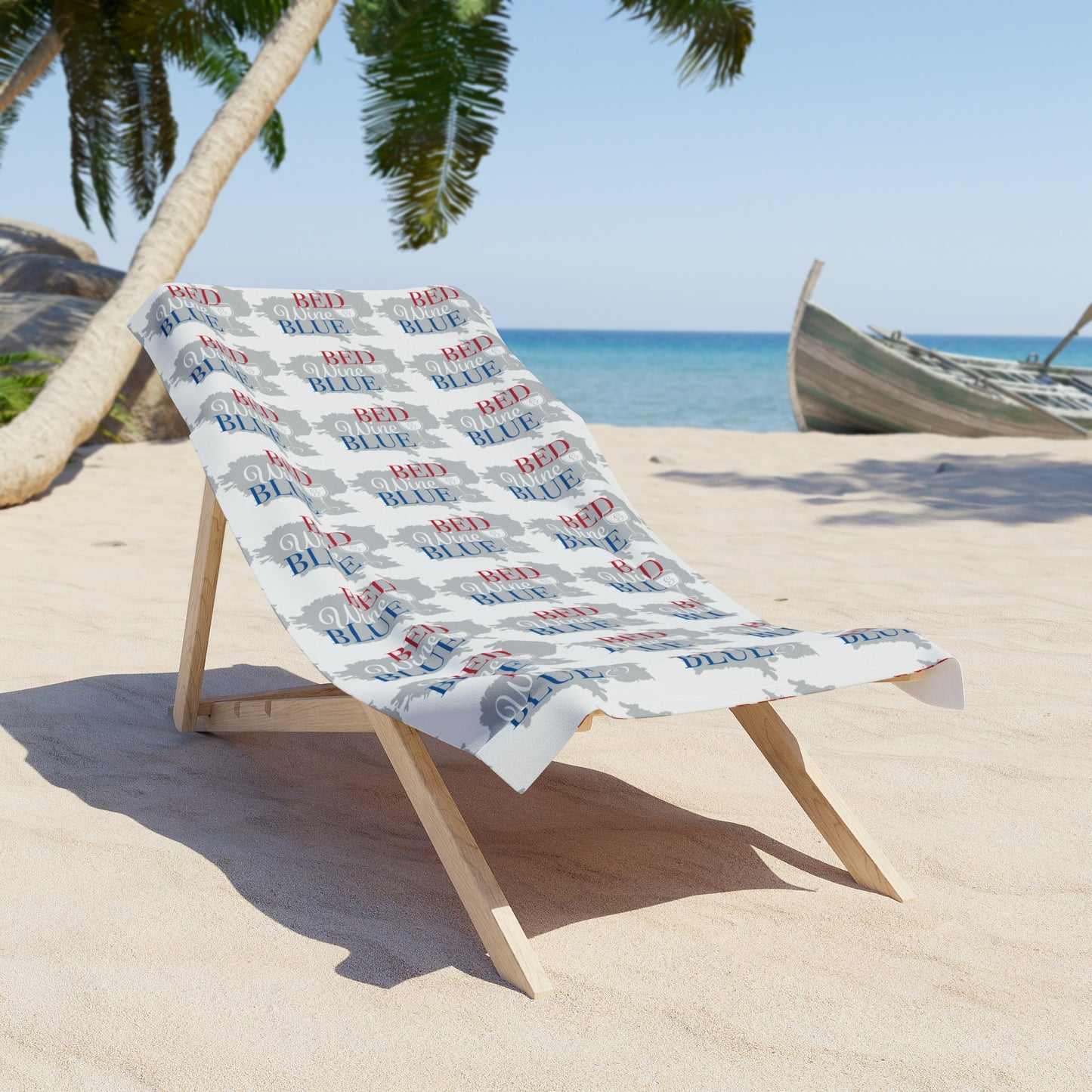 White beach towel draped on wooden stand, red and blue script pattern