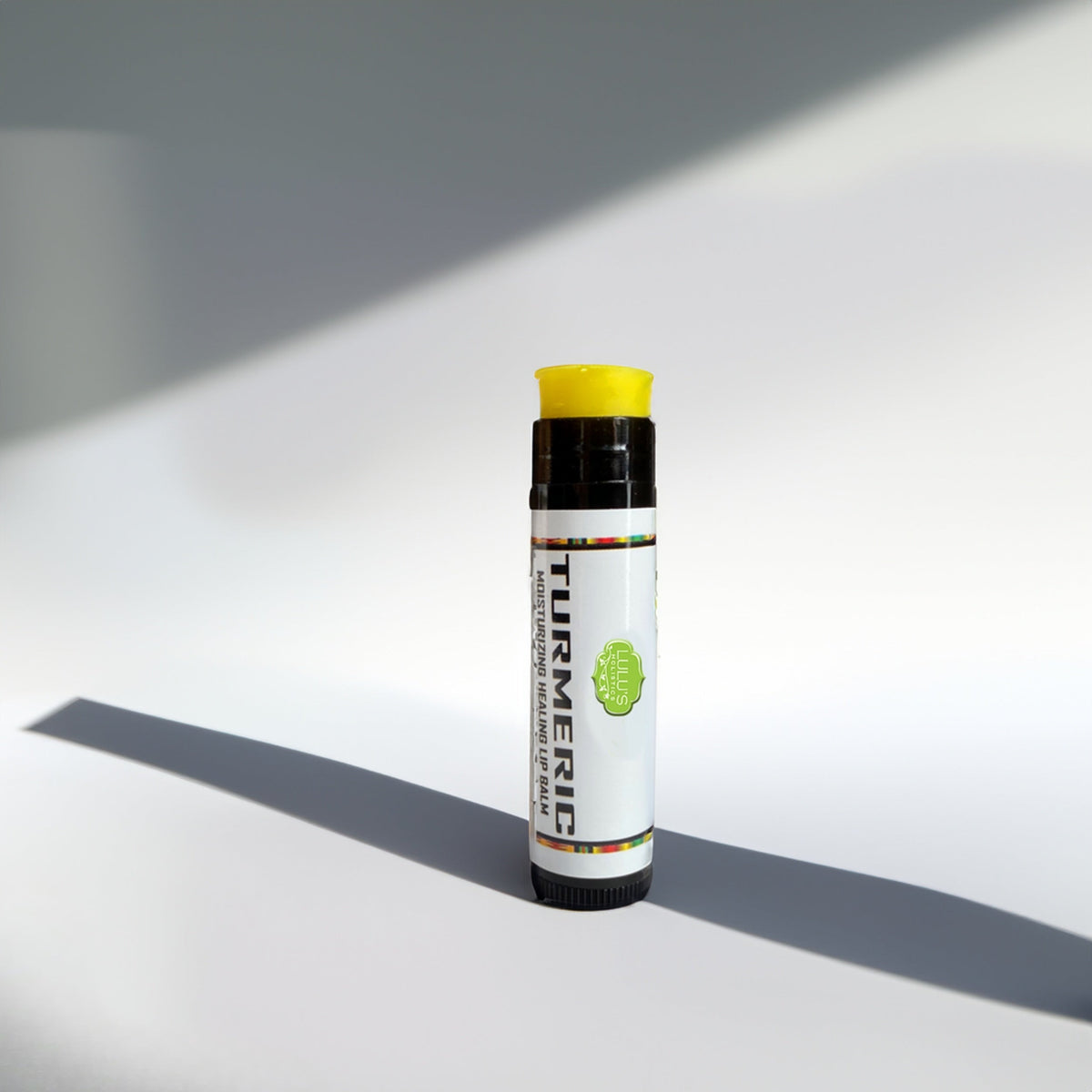 Lip repair balm tube with yellow cap and black base label