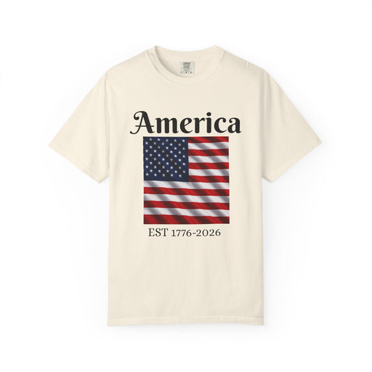 Ivory T-shirt with America graphic and American flag, text EST 1776-2026.