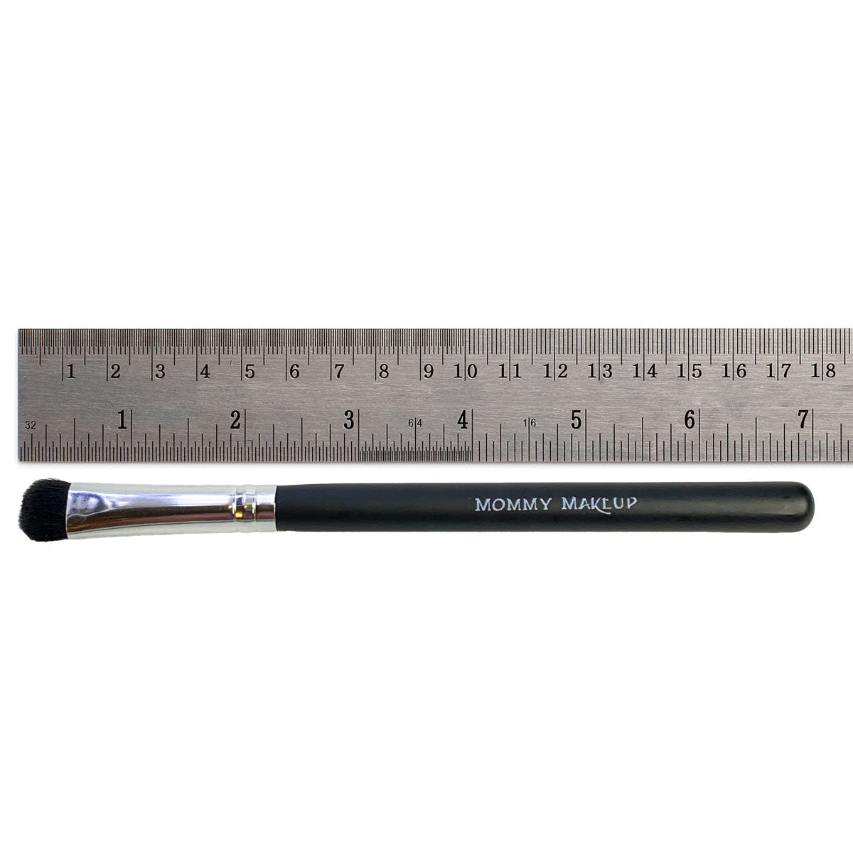 Shadow brush with black handle, silver ferrule, and domed bristles; ruler shows size