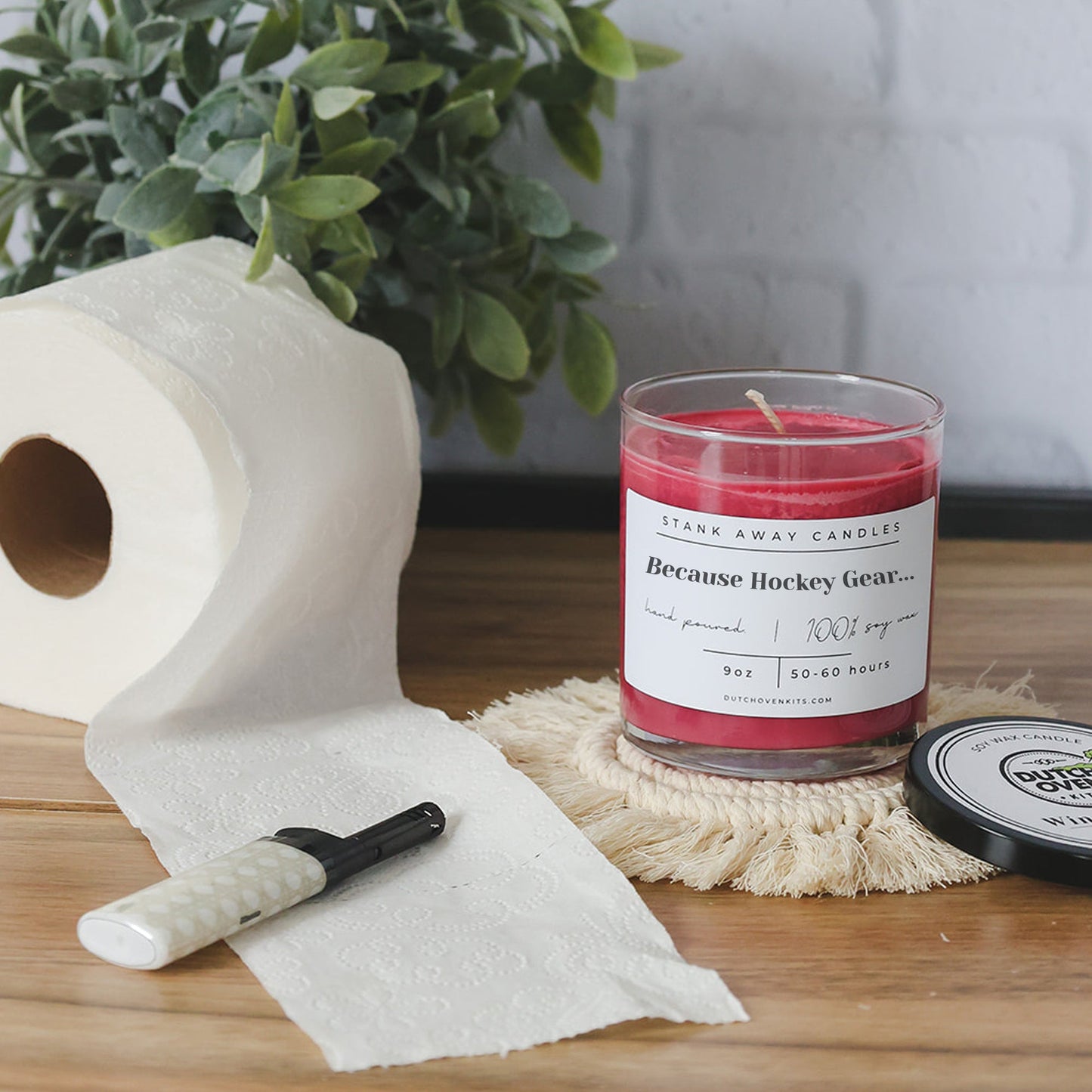 Clear glass soy wax candle with red wax and printed "Because Hockey Gear" label