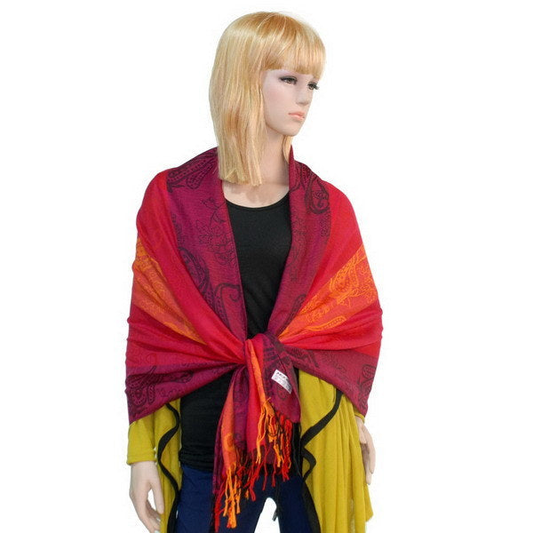 Paisley pashmina scarf draped in burgundy, orange-red, and yellow with fringed ends
