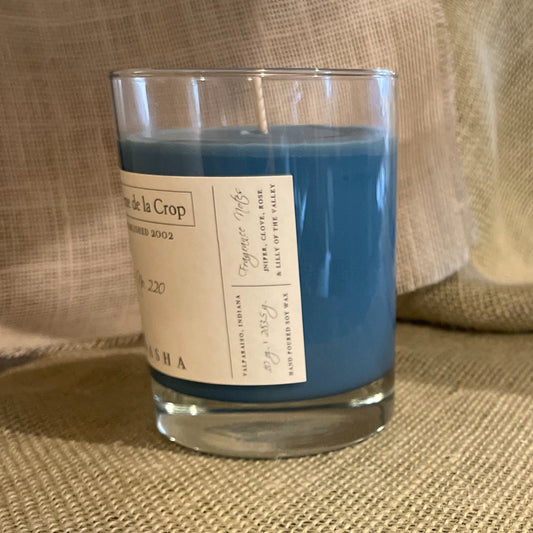 Soy candle with blue wax in clear glass jar, cream label detail