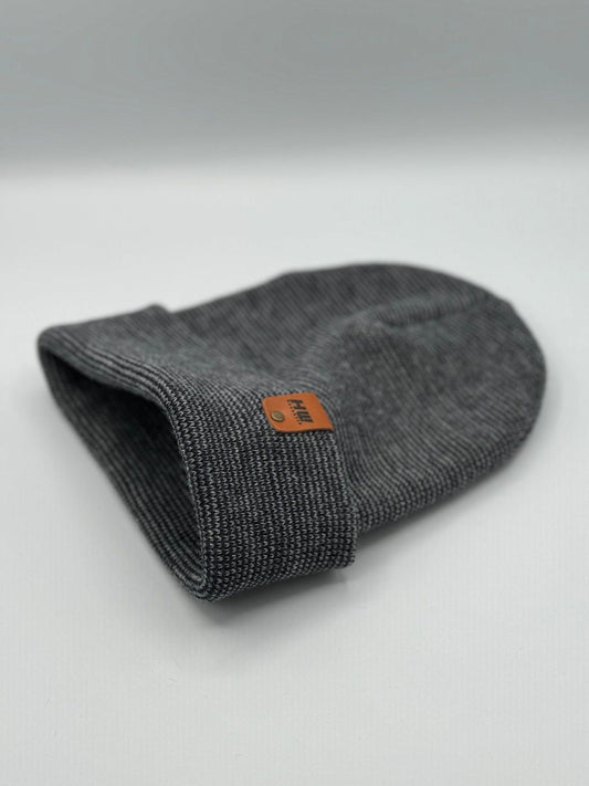 Dark gray knit beanie cuff folded, showing orange logo tag
