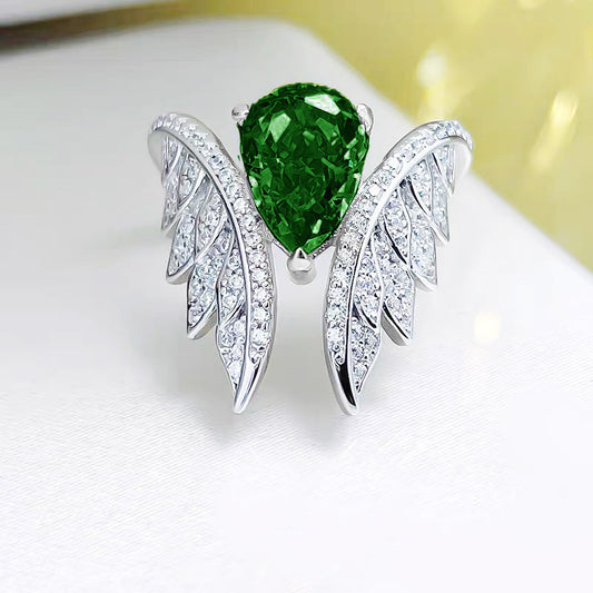 Front view silver wing cluster engagement ring with green pear-shaped stone and pavé settings