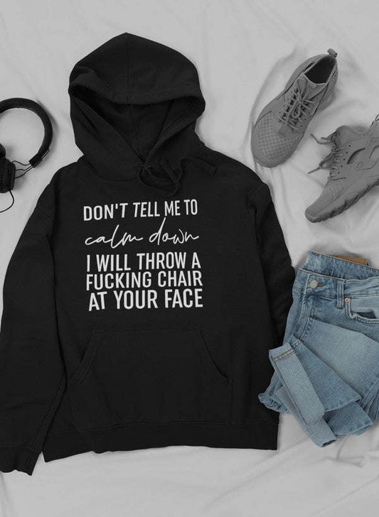 Black pullover hoodie with front pocket and drawstring, printed slogan on chest
