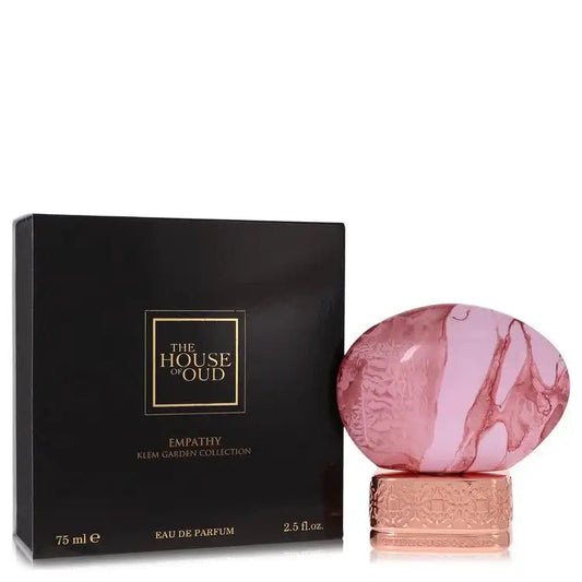 Unisex eau de parfum box and glass bottle, dark packaging with gold logo and pink bottle