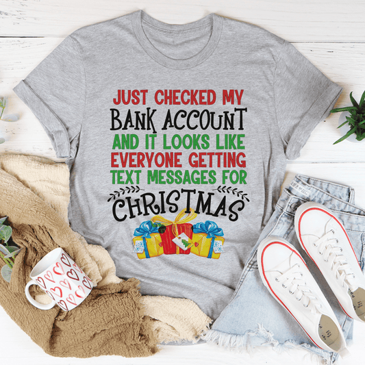 Gray crewneck T-shirt with “Just checked my bank account” Christmas text graphic