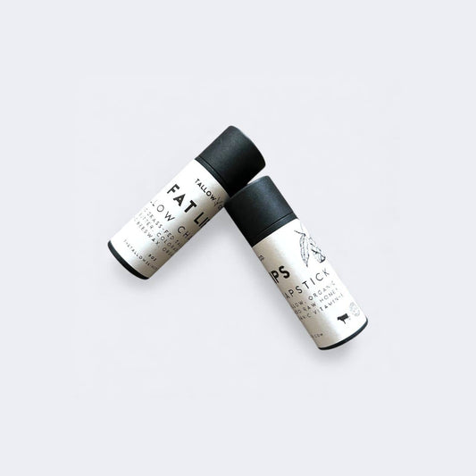 Tallow lip balm tubes with black caps and pale printed labels