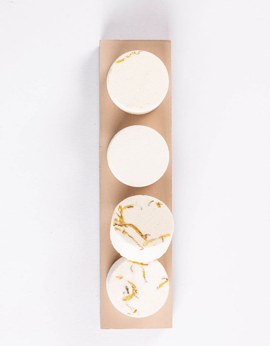 Shower steamer discs set: four pale round discs with gold flecks in kraft sleeve