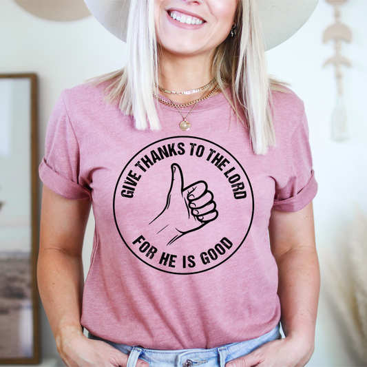 Mauve T-shirt with front circular thumbs-up graphic and “Give thanks” lettering