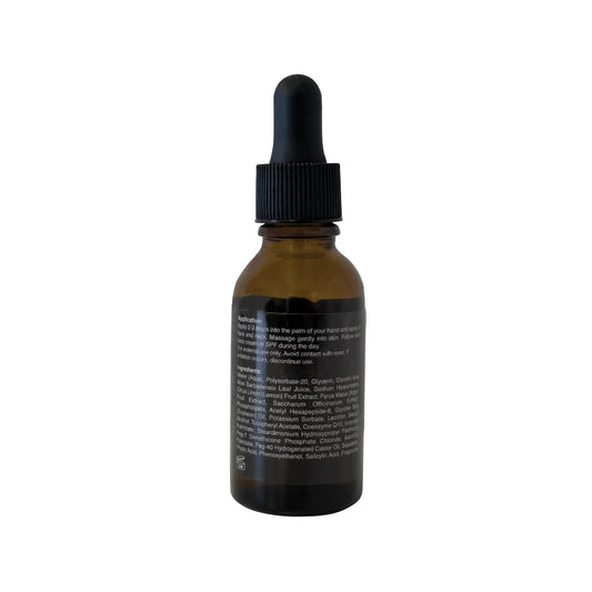 Glycolic acid serum bottle, back label facing camera, amber glass with black dropper