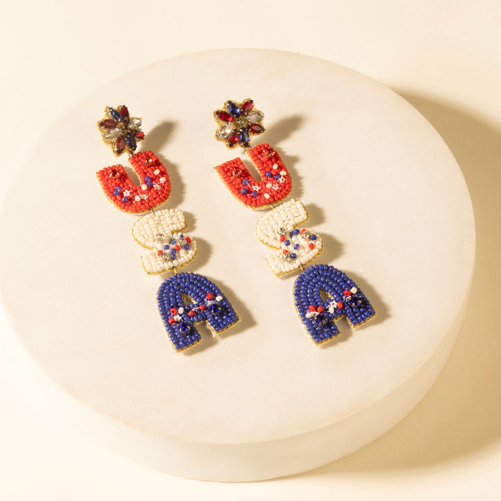 Beaded drop earrings featuring red, white, and navy-blue charms with floral top details.