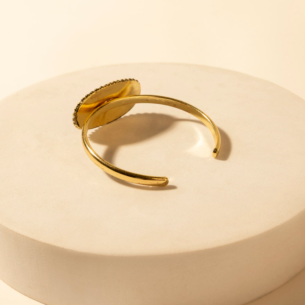 Gold tone open cuff bracelet with smooth band and rounded ends