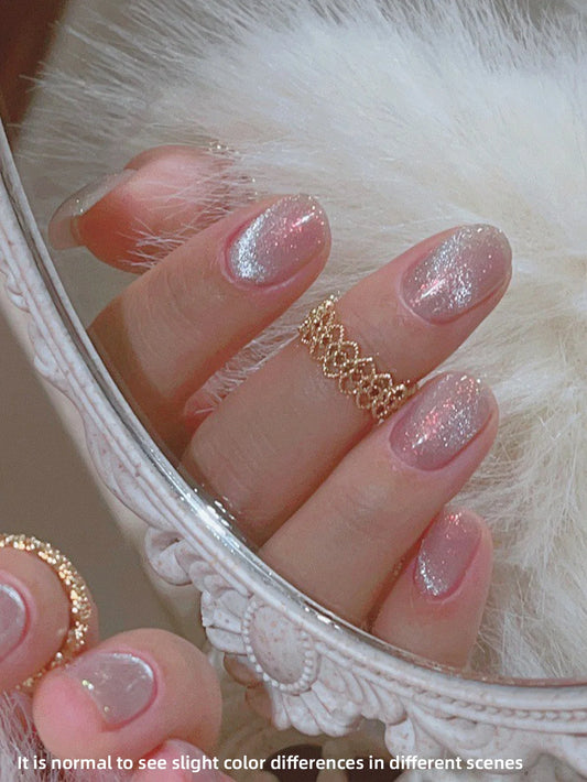 Cat eye style nails with pink base and silver glittery shimmer, close-up