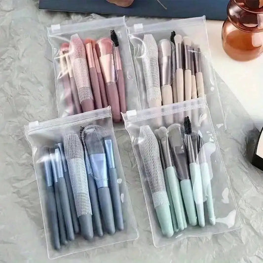 Mini makeup brush set in clear pouches, blue and pastel handles with textured grips.