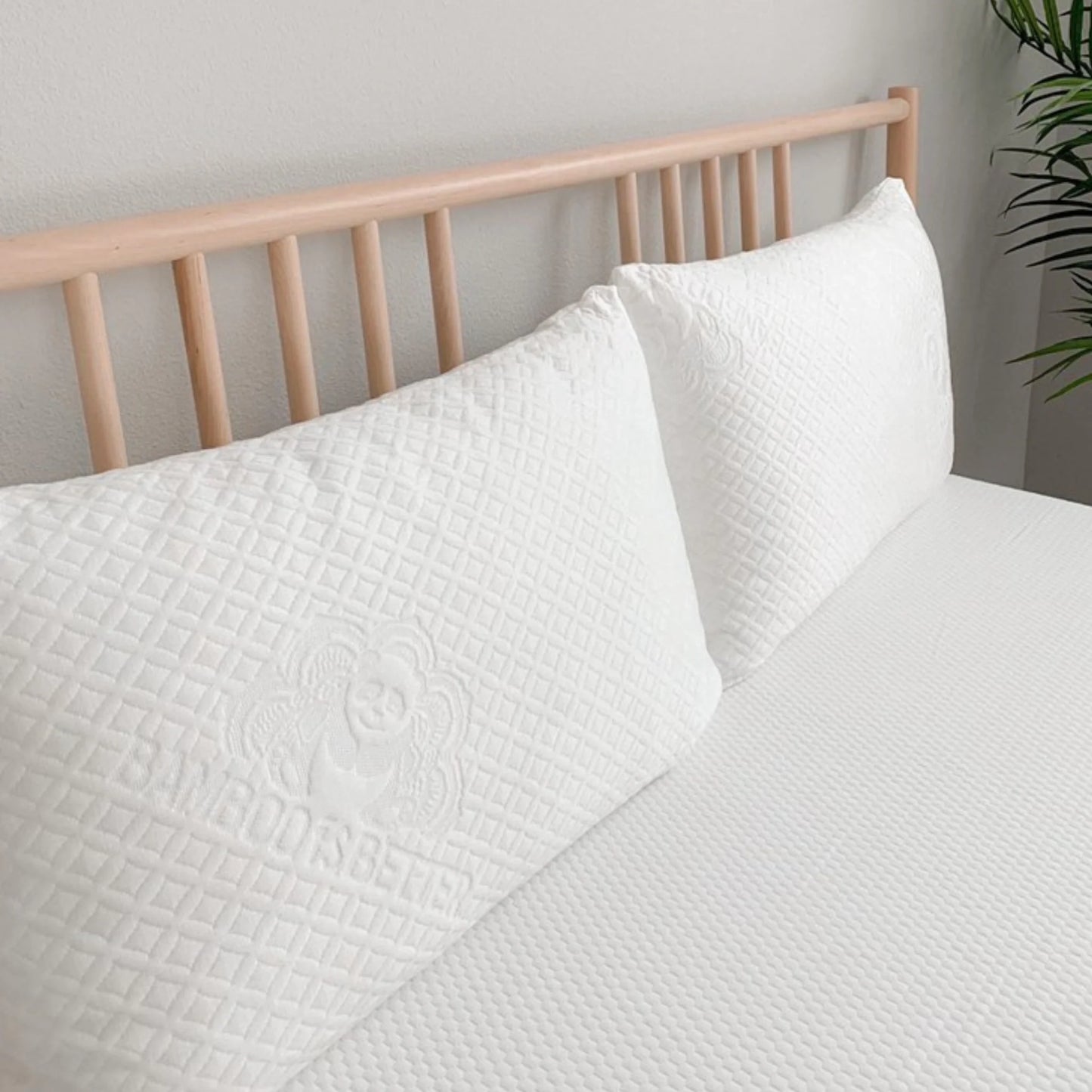 White quilted pillow cover with stitched floral emblem, square edge