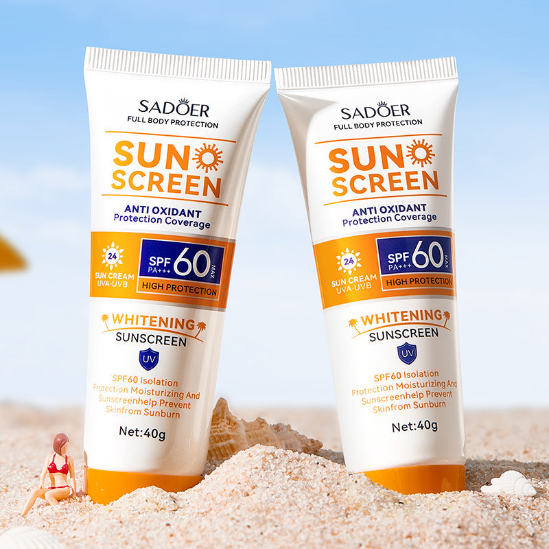 Two SADOER Sun Screen SPF 60 sunscreen tubes on sand with orange accents