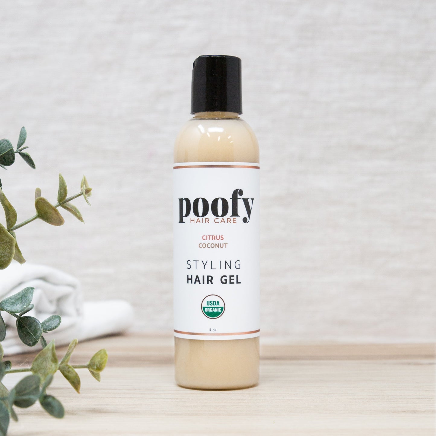 Poofy styling hair gel bottle with black cap, beige bottle, Citrus Coconut label