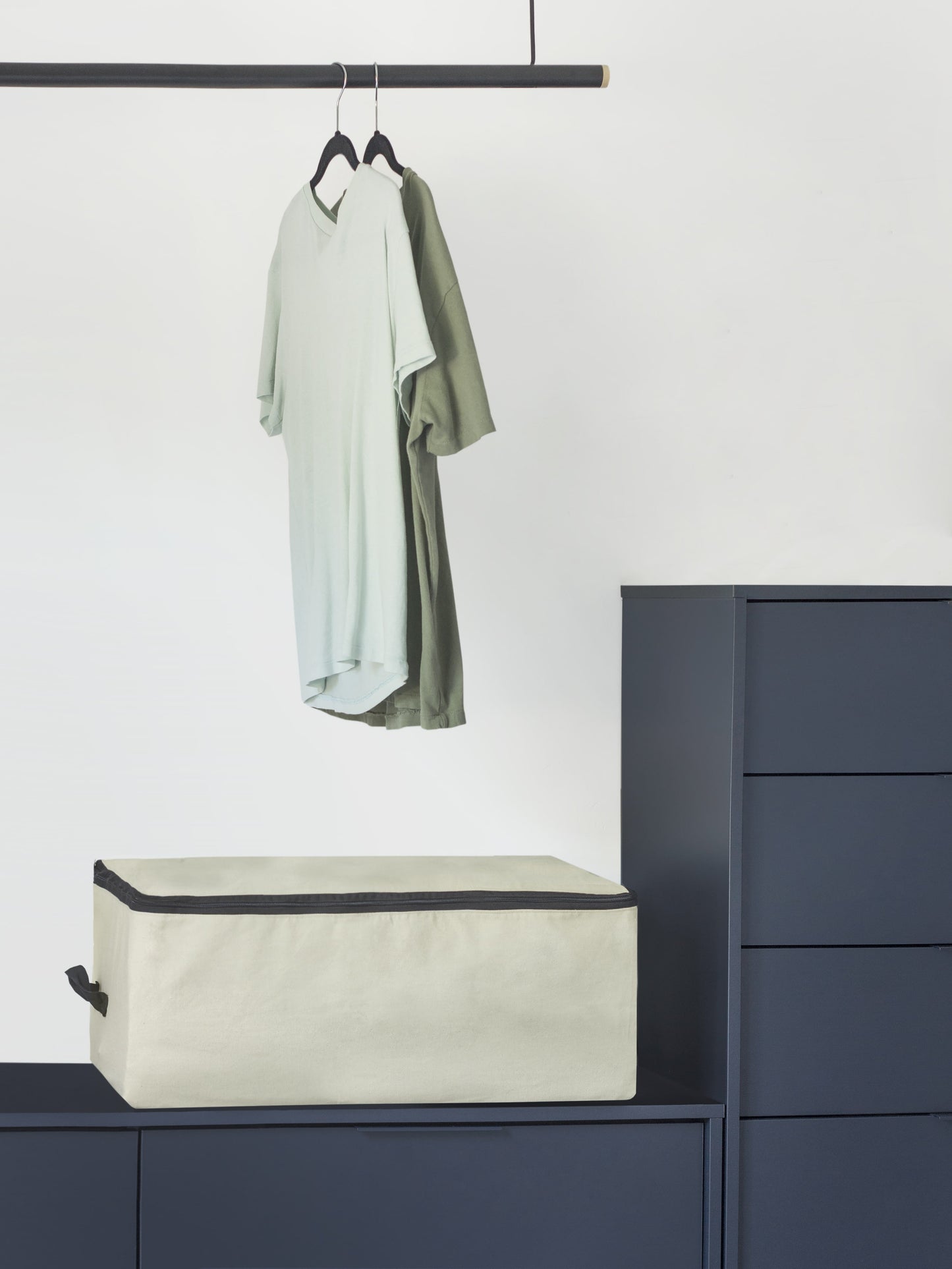 Comforter storage bag on cabinet top, beige with black trim and top zipper