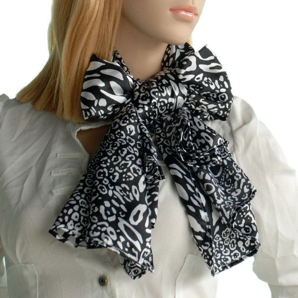Small leopard-print silk scarf in black and white with bow-like tie, worn by model