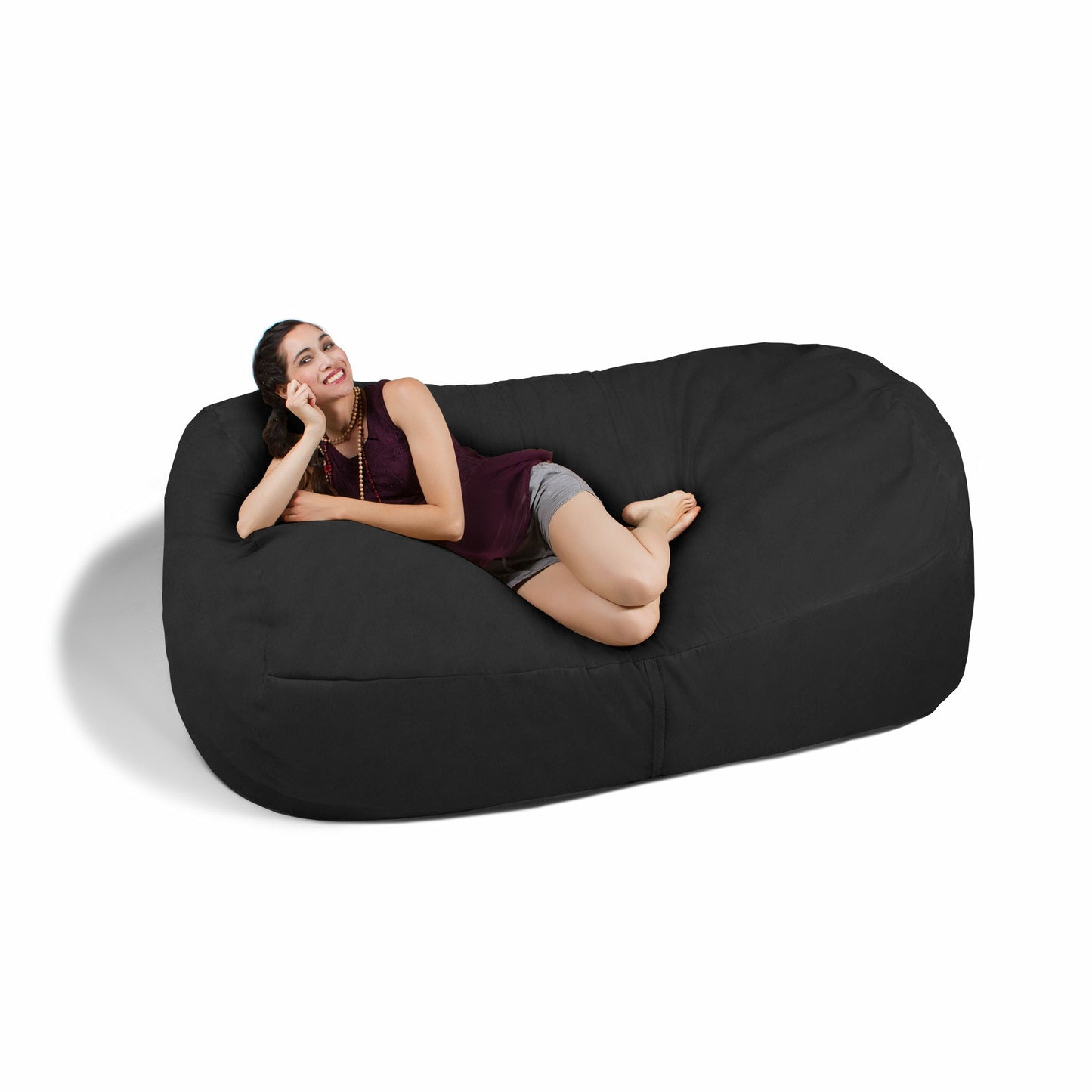Black giant bean bag sofa with a person lounging reclined, curved cushion