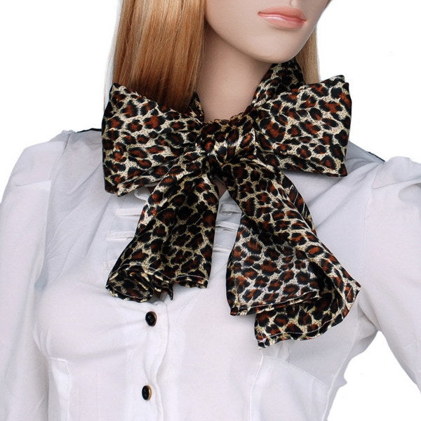 Silk scarf with leopard print tied in a bow at the neck, dark brown and cream spots