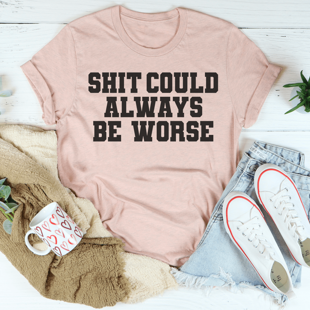 Light mauve T-shirt with bold text 'SHIT COULD ALWAYS BE WORSE'