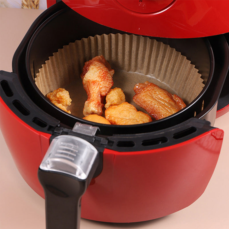 Brown round air fryer paper liner mat with chicken pieces in basket