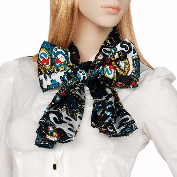 Paisley scarf with long tails tied at the collar, teal and black with colorful motifs