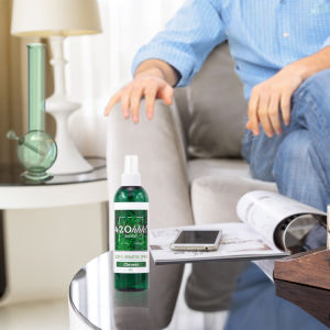 Green 420hhh odor eliminator spray bottle with white mist pump on a table surface.