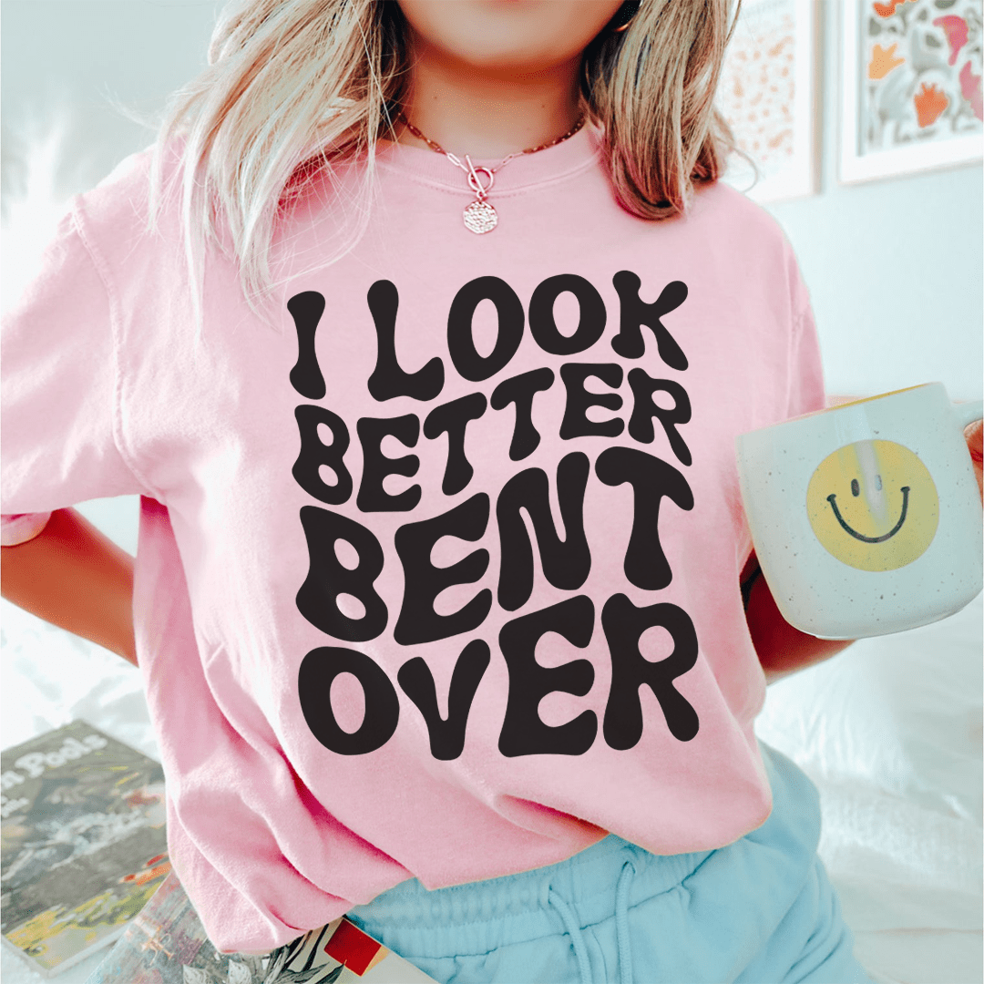 Pink T-shirt with black 'I Look Better Bent Over' text graphic