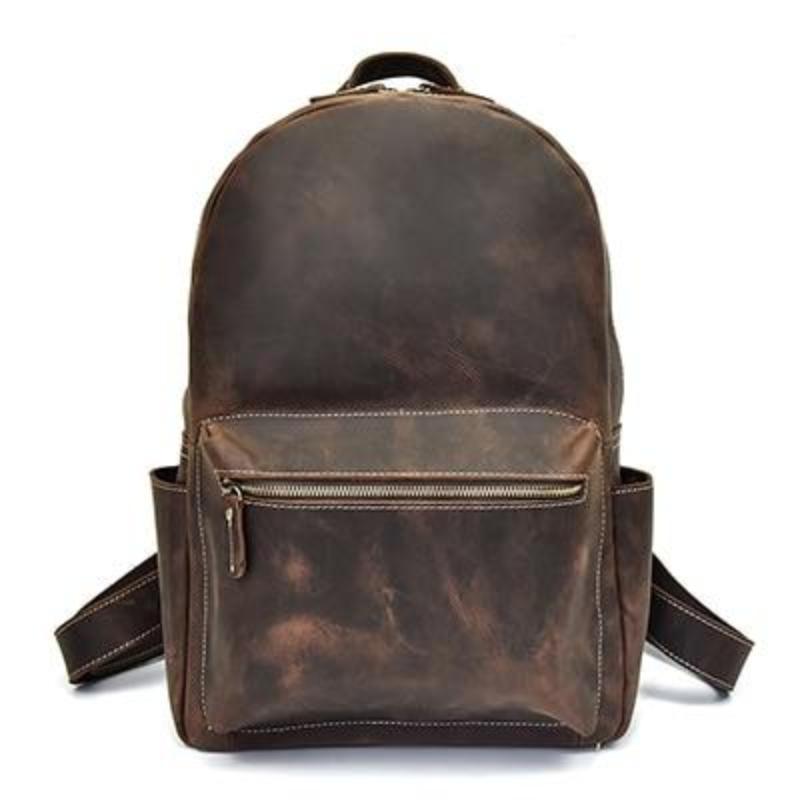 Brown leather backpack with front zip pocket, top handle, and adjustable shoulder straps.