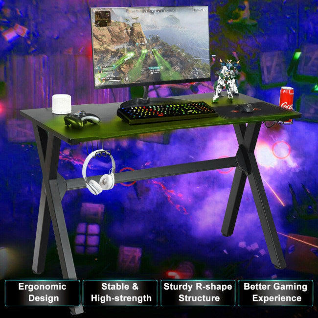 Black gaming desk with mouse pad, keyboard, and cup holder with headset