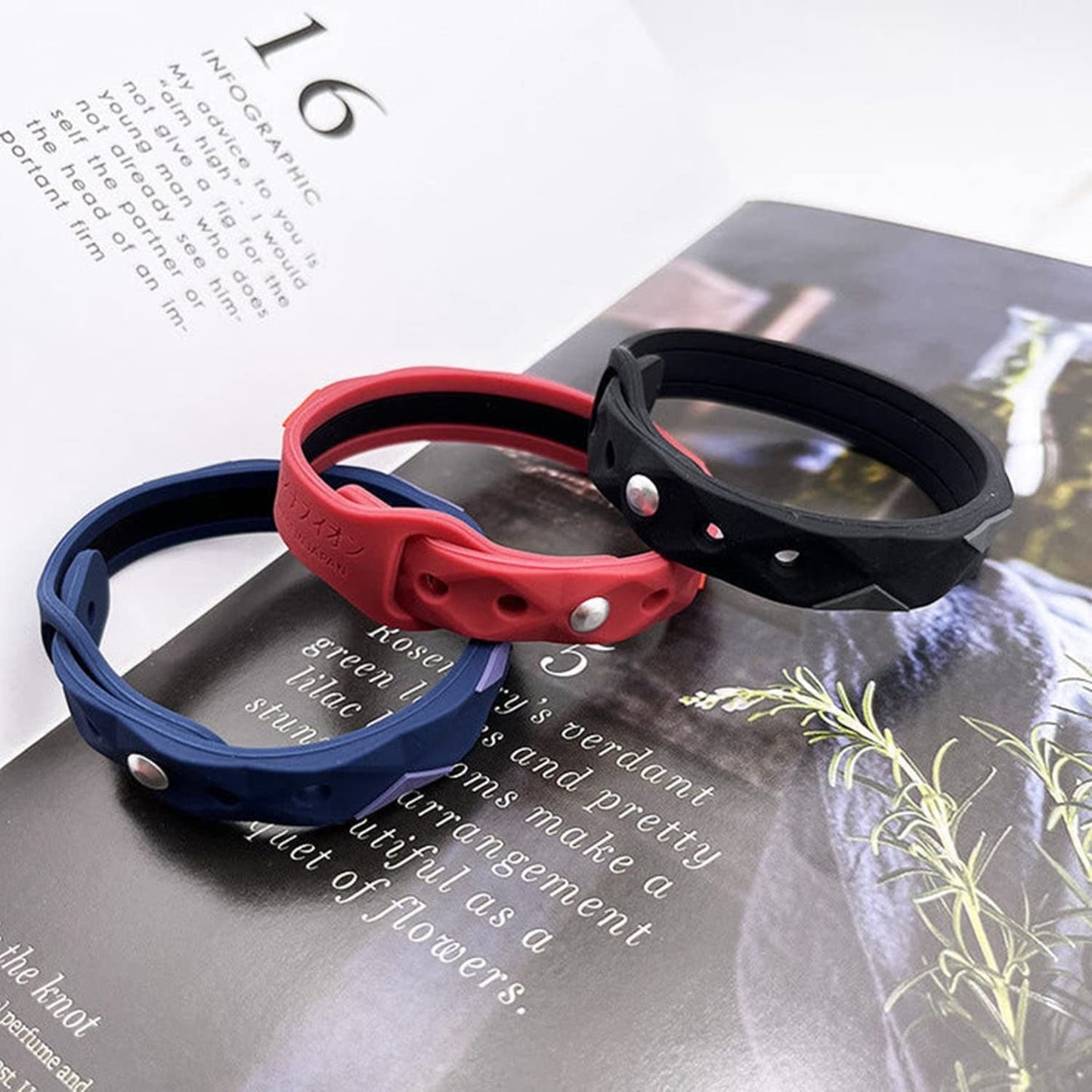 Three anti-static bracelets in red, black, and blue with snap buttons