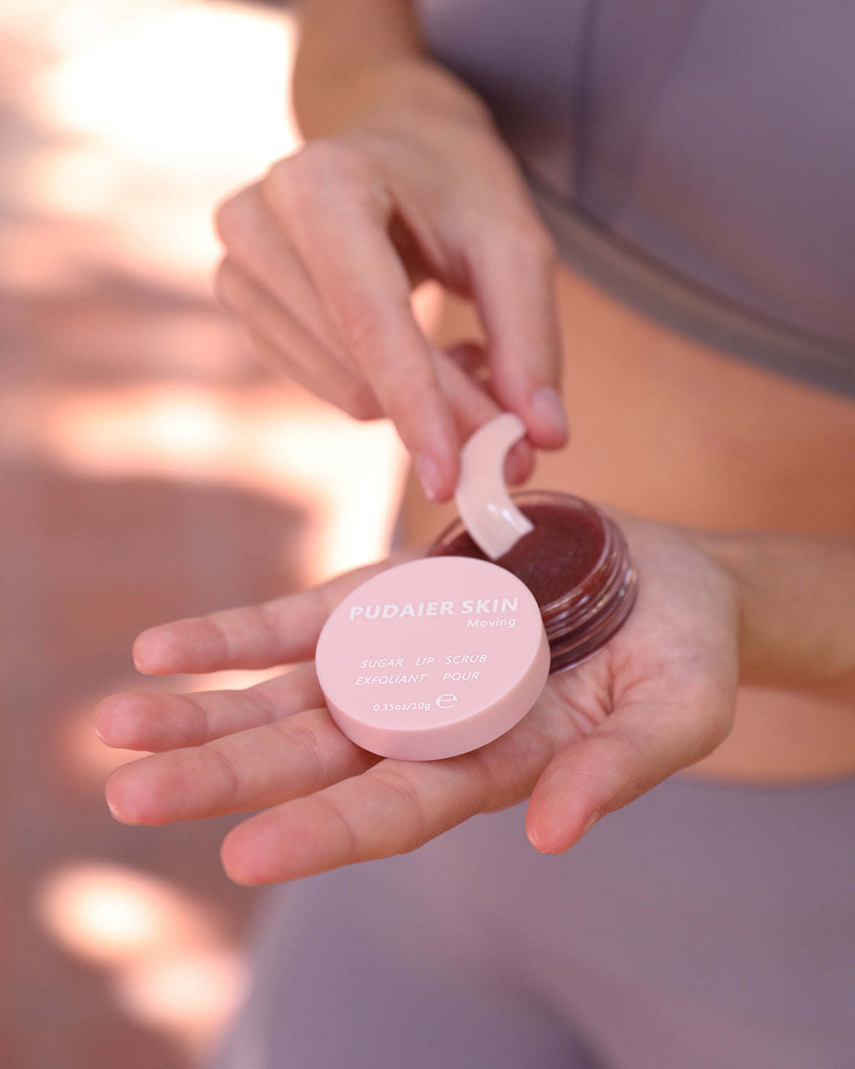 Pudaier lip scrub in round jar, dark grape-toned balm and white lid