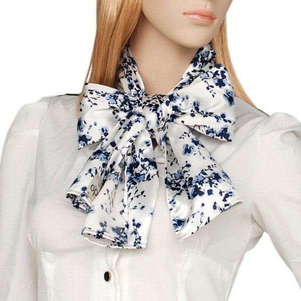 White silk scarf with blue plum blossoms tied in a bow at the collar