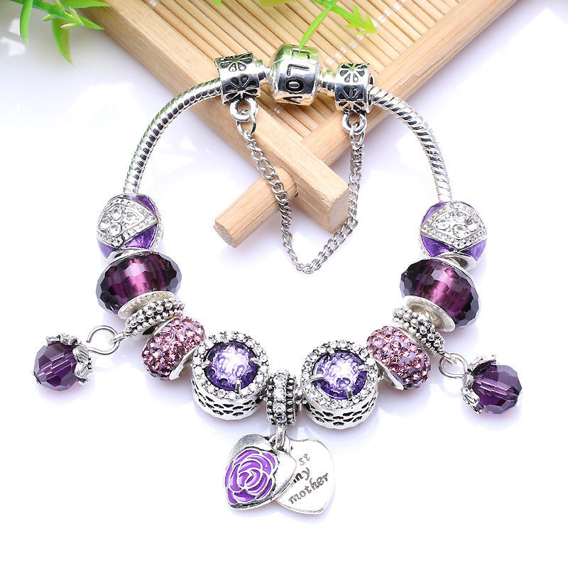 Silver charm bracelet with purple rhinestone beads, floral heart pendant and tag charm