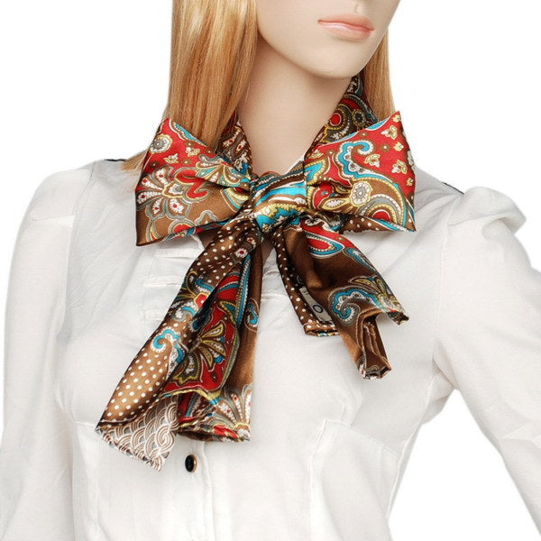 Silk paisley scarf knotted at the neck, teal and red accents on a brown dotted base