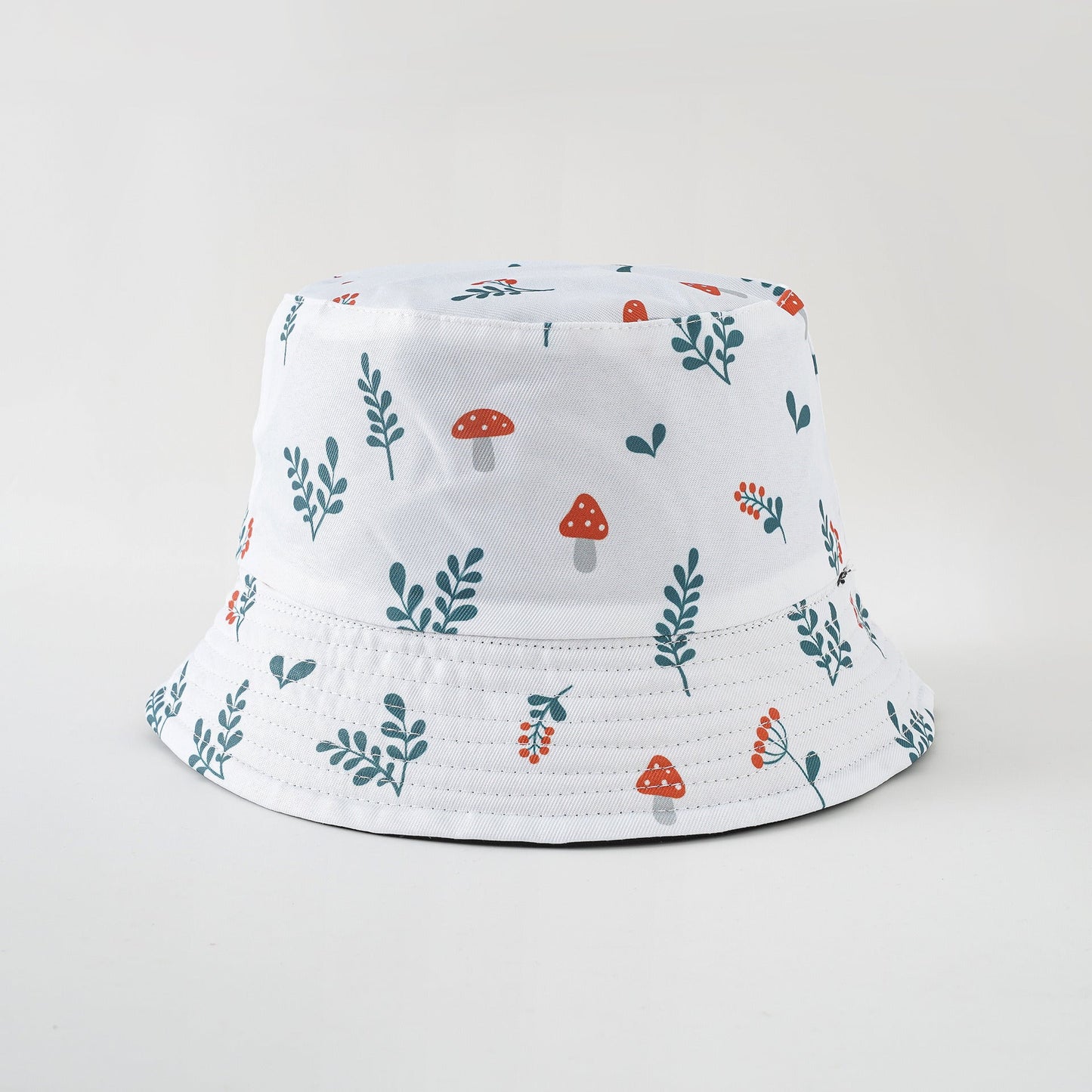 White bucket sun hat with mushroom and green leaf pattern