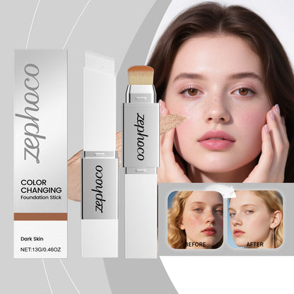 Color-changing foundation stick with brush tip on model cheek, with boxed package