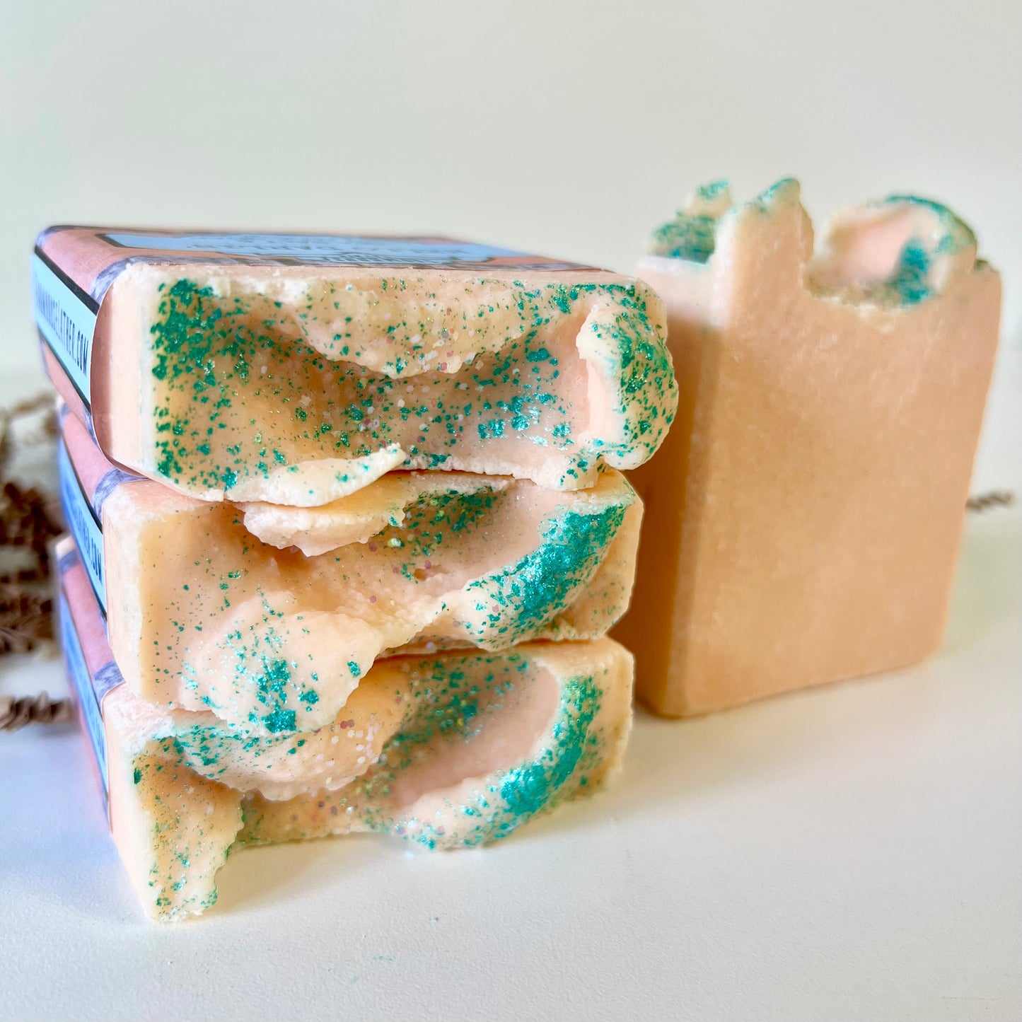Sea salt soap bar stack with teal speckles and a second bar, side view