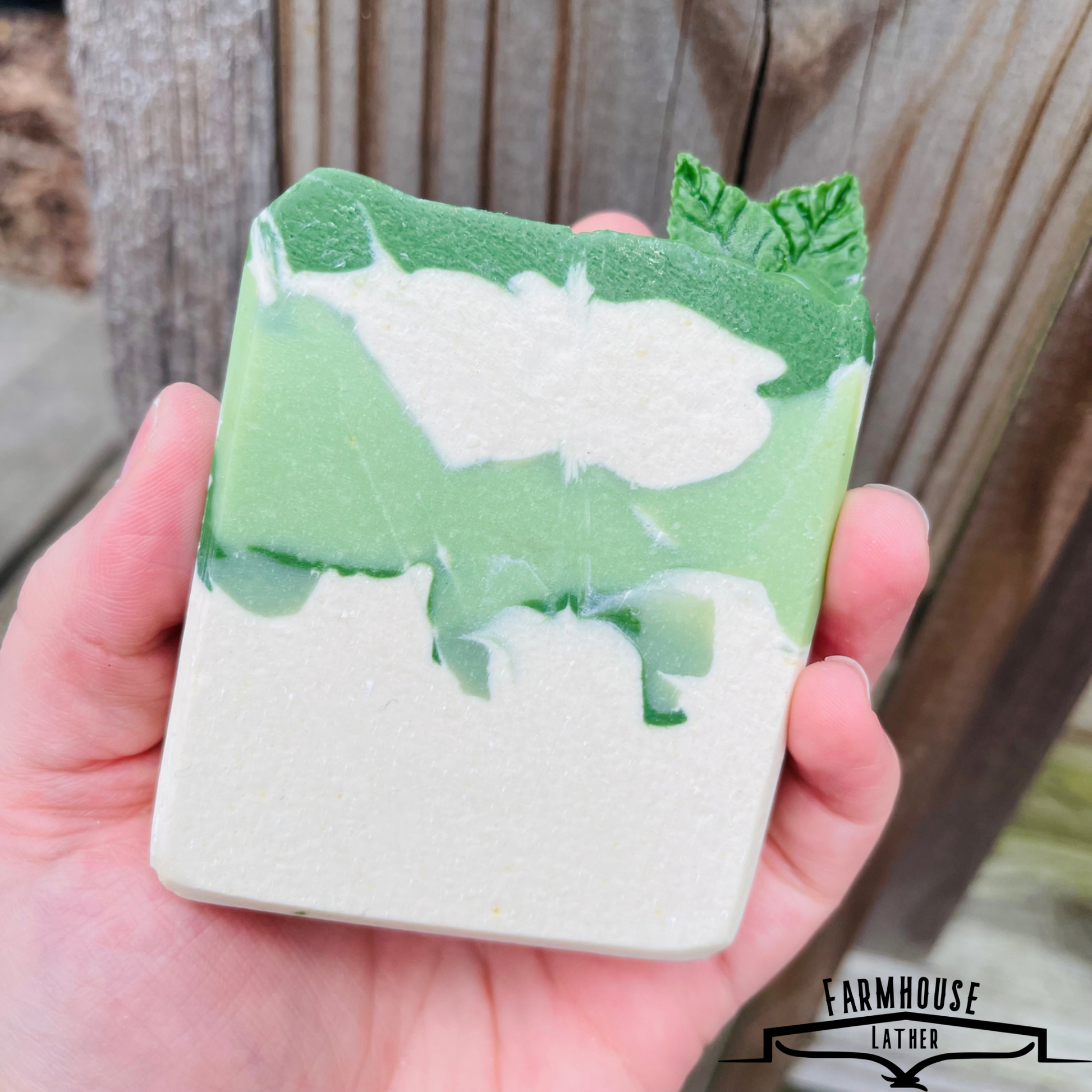 Spearmint soap bar in hand, green and white swirl pattern with textured top.