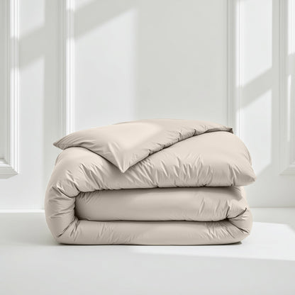 Light gray sateen bedding bundle with a folded duvet and pillow stack