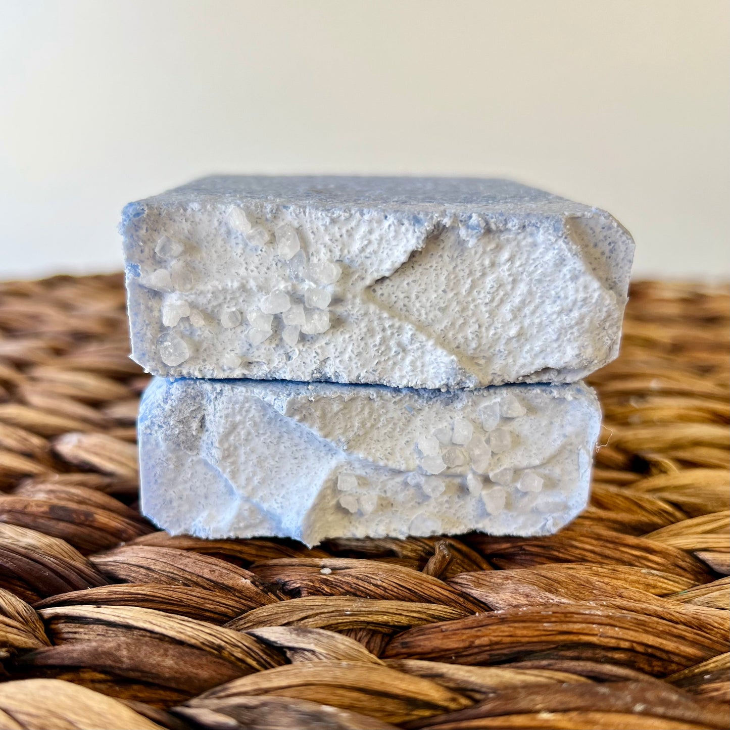 Sea salt bar, two stacked blocks with rough pitted texture and light blue hue