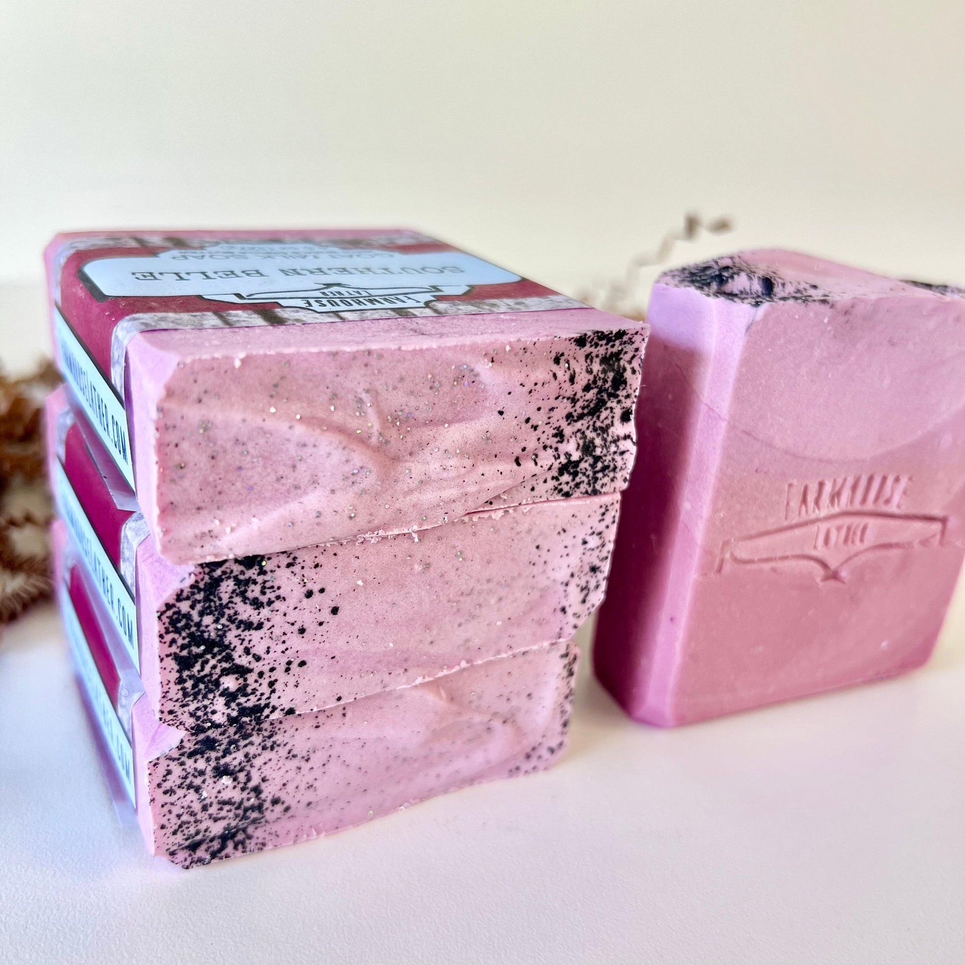Pink goat milk soap bar set with black speckles and FARMHOUSE LATTER logo