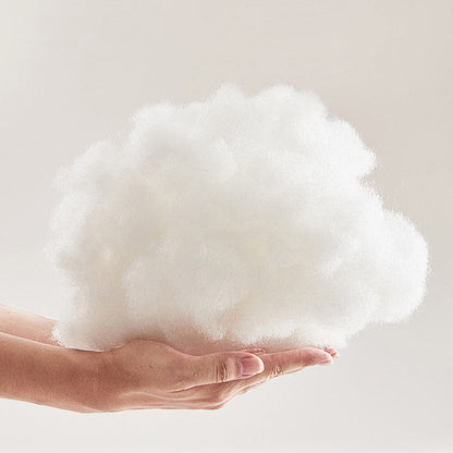Soft white plush fabric cushioning, held in a hand for a thick, fluffy texture.
