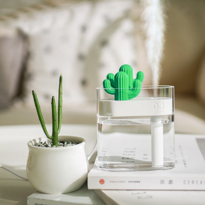 Ultrasonic air humidifier with green cactus insert in clear tank, mist billowing above